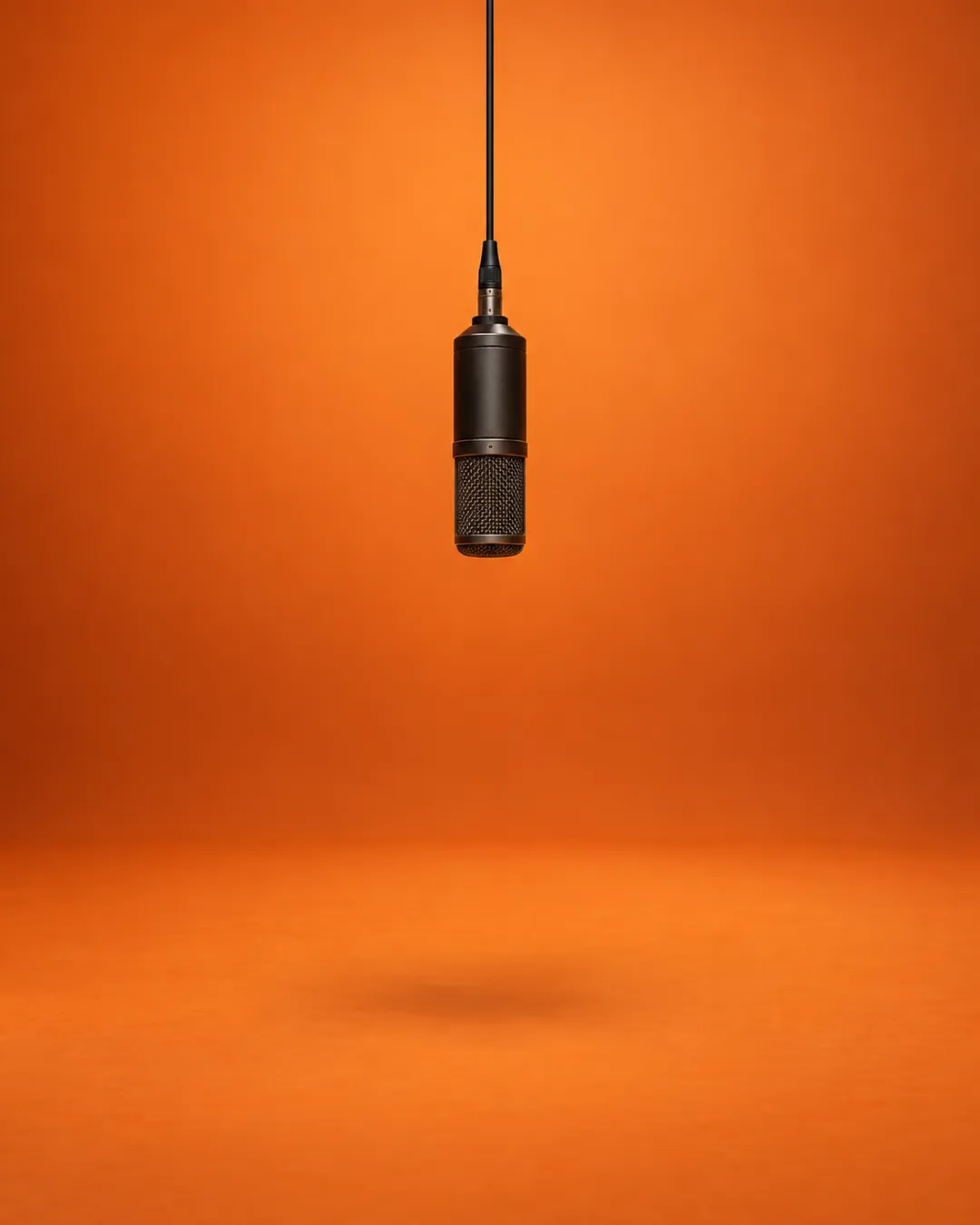 Orange studio booth with a single hanging microphone, the set used in hotel lobby AI videos